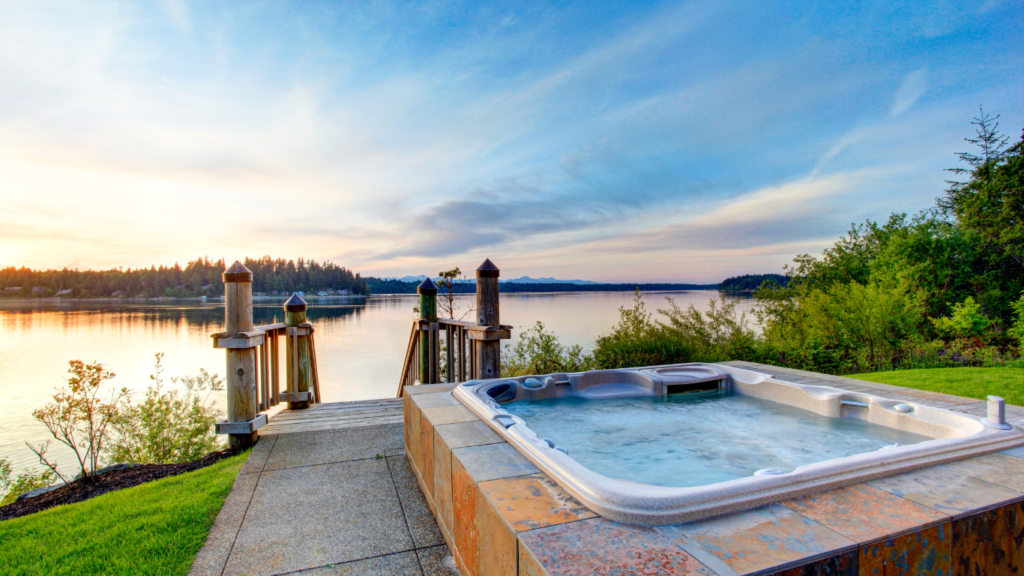 Water view with hot tub at dusk