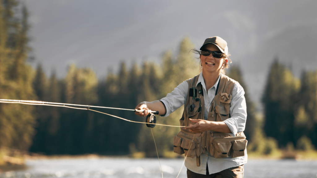 Smiling woman fly-fishing trout on a British Columbia river