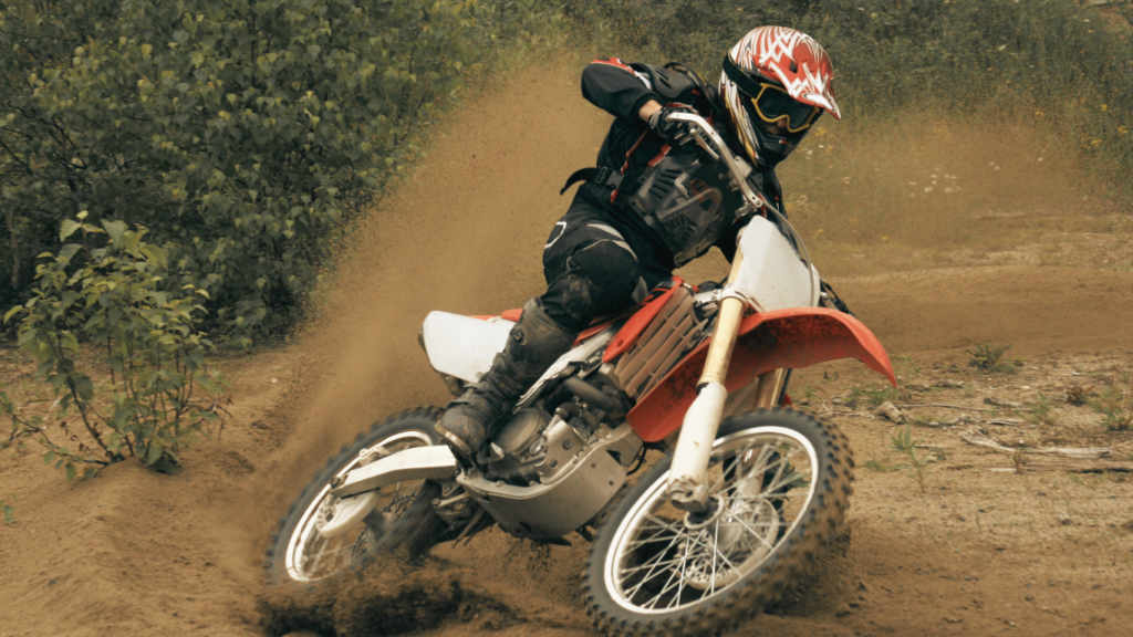 A dirt bike rider riding through the dirt⁠