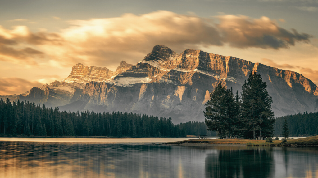 Early autumn morning on the lake shore. Wonderful sun and clouds over Mount Rundle in Banff